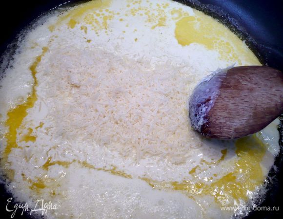 В это время растапливаем на сковороде сливочное масло, добавляем сливки и 75 г сыра типа Пармезан, а также чеснок. Размешиваем до однородности и даем покипеть в течение 3 минут.