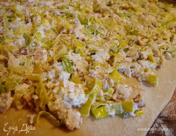 Тесто раскатать на присыпанном мукой столе в прямоугольник, такой же толщиной, как на лапшу. Равномерно распределить начинку по поверхности и свернуть тесто в плотный рулет.