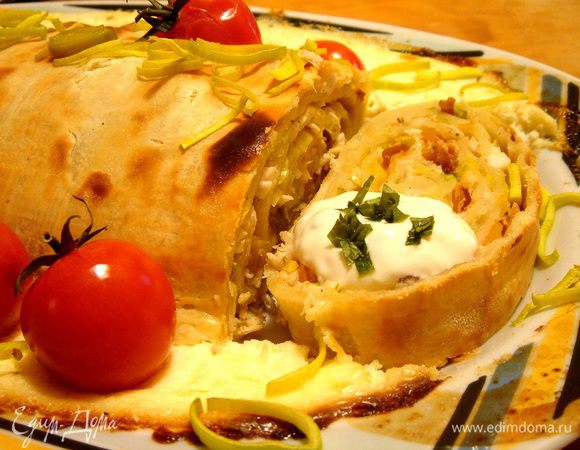 Готовый рулет смазать растопленным сливочным маслом, присыпать базиликом или колечками лука порея. Подавать с соусом. Для этого смешать сметану с измельчённым базиликом и натёртым на мелкой тёрке Пармезаном. Приятного аппетита!