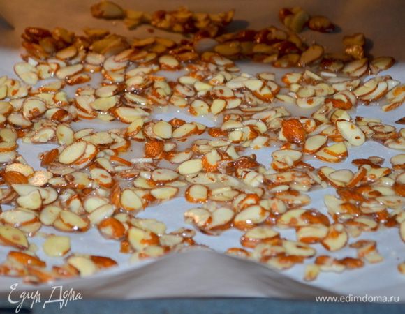 Застелить противень бумагой для выпечки. Выложим распределив по бумаге приготовленный миндаль.