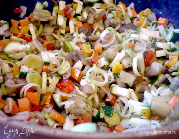 Баклажаны кладем в кипящую воду на пять минут, затем даем им слегка остыть и снимаем кожуру. Чистим лук, морковь, отрезаем от лука-порея светлую часть и чистим чеснок. Капусту разделяем на листочки, внутреннюю часть, похожую на цветок, оставляем нетронутой, она нам понадобится для украшения. Режем мелко цуккини, светлую часть лука-порея, репчатый лук, морковь, а чеснок натираем на терке. Баклажаны и паприку режем также на мелкие кубики. Все овощи, кроме капусты, перемешиваем, добавляем базилик, сухие травы, сок лимона и томатную пасту, солим и перчим. 