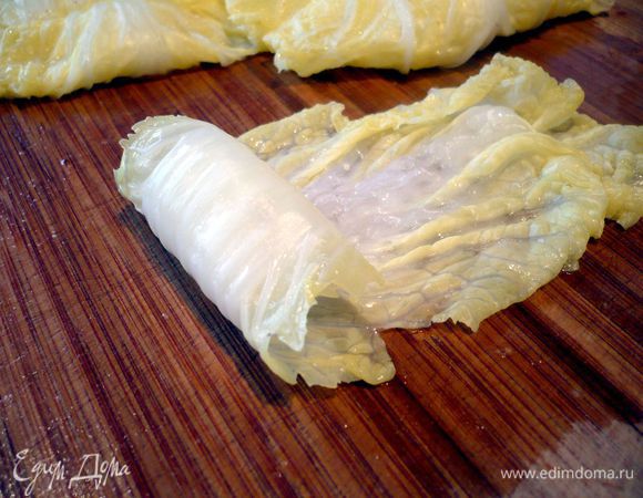 Листья капусты заливаем кипятком и оставляем на пять минут. Моцареллу обтираем полотенцем и режем на кубики. Откидываем листья капусты на сито, даем стечь воде, солим и отбиваем их молотком, сворачиваем в рулеты и даем минут пять полежать, чтобы они лучше могли сохранять форму с начинкой. 