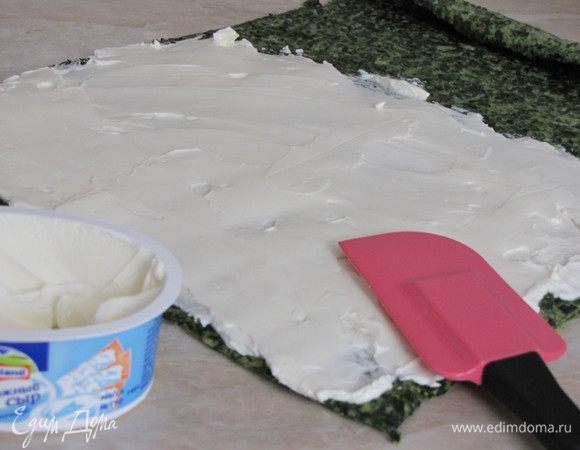 Разверните рулет и намажьте сливочным сыром.