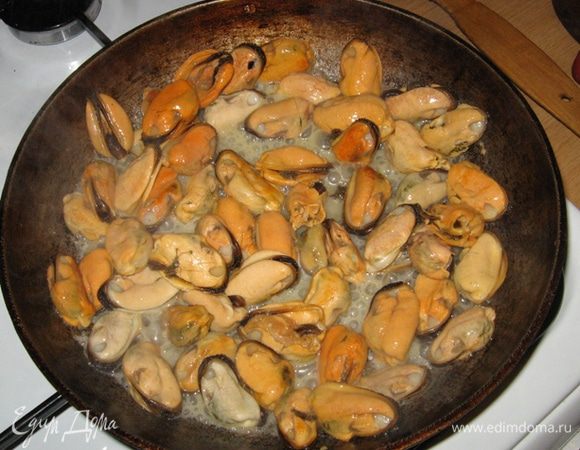 Мидии полностью размораживаем, но не отжимаем (пусть в них еще будет влага - пригодится) и выкладываем к луку, солим, перчим, вливаем вино и воду и на сильном огне жарим минуты 3, максимум 5, постоянно помешивая.
