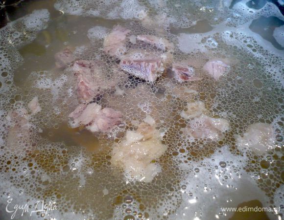 Мясо режем на кусочки и отправляем в процеженный бульон, ставим на огонь.