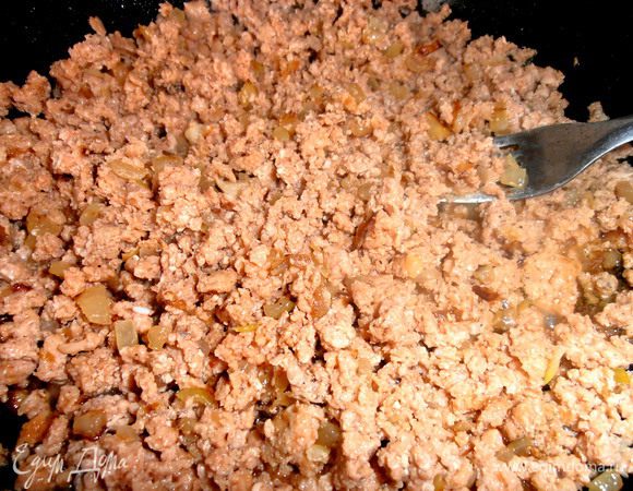 Продолжая жарить минут 5, перемешать и измельчить при помощи вилки.