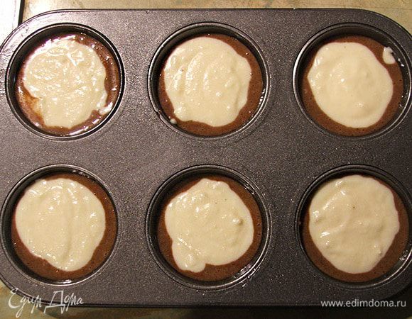 Разлить тесто по формочкам, по паре столовых ложек в каждую. Сверху выложить крем-чизовый наполнитель - тоже по две-три ложки.