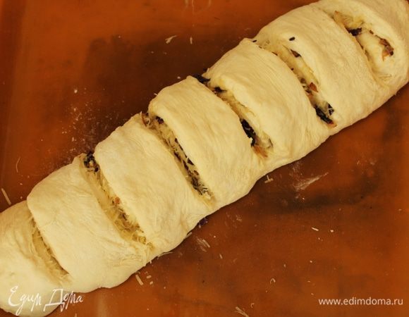 Свернуть тесто с начинкой рулетом, переложить на противень и сделать поперечные надрезы. оставить на расстойку на 30 минут. 