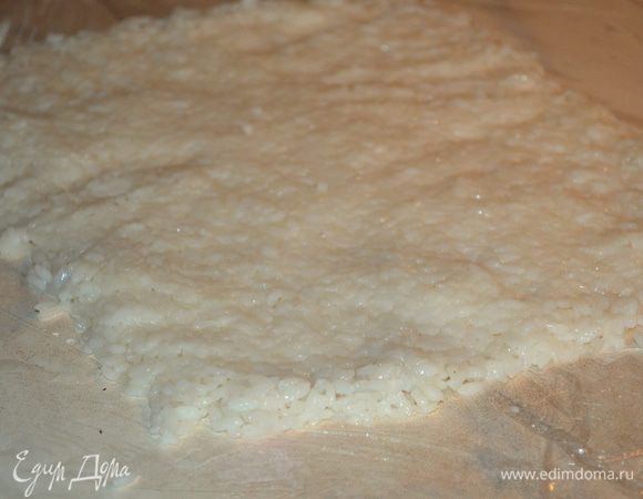 На столе расстелить пищевую пленку. Выложить на нее остывший рис и разровнять в прямоугольник толщиной 5-7 мм. Размер у меня примерно 25х30 см