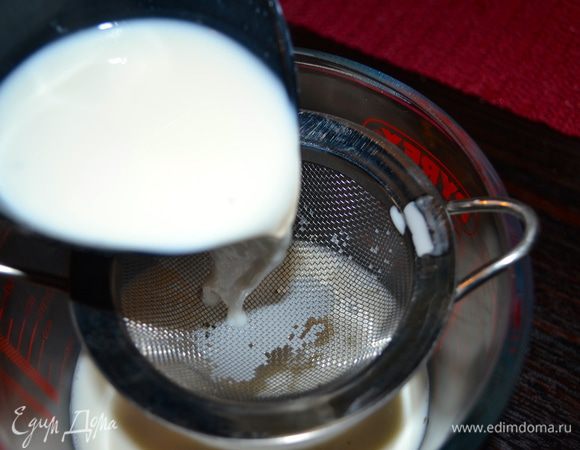 Фильтруем молоко через ситечко и небольшую его часть добавляем ко взбитым желткам. Быстро как следует все перемешиваем, чтобы не допустить свертывания яичной массы. 