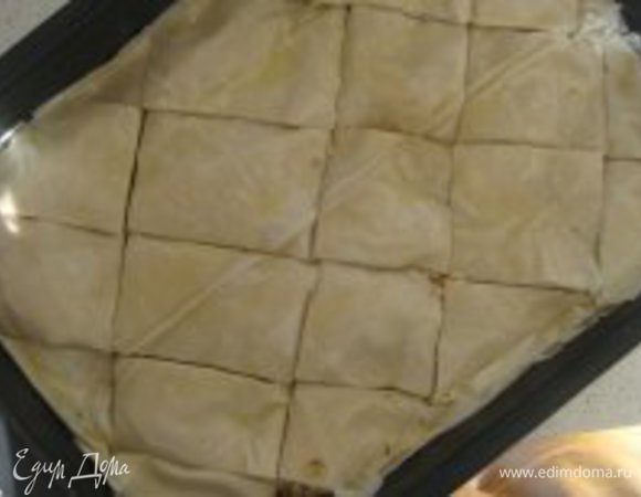 Перед тем как поставить баклаву в духовку, ее необходимо разрезать на ромбики (на половину глубины слоев теста). Выпекать в разогретой до 180 градусов духовке примерно 30 минут, затем увеличить нагрев духовки до 220 градусов и выпекать еще 5 минут