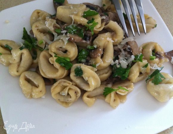 Добавить 2 стакан воды, приправить солью и перцем. Готовьте, пока жидкость не уменьшится в два раза, около 10 минут. Снять с огня, добавить тортеллини, сыр, масло и петрушку. Размешивать, пока масло расплавится и петрушка смягчится. .