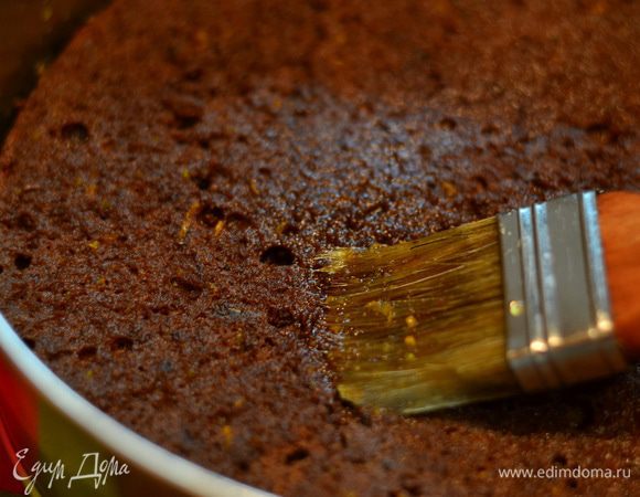 Первый корж поместите в форму, пропитайте еще теплым апельсиновым сиропом, пропитки не жалейте!