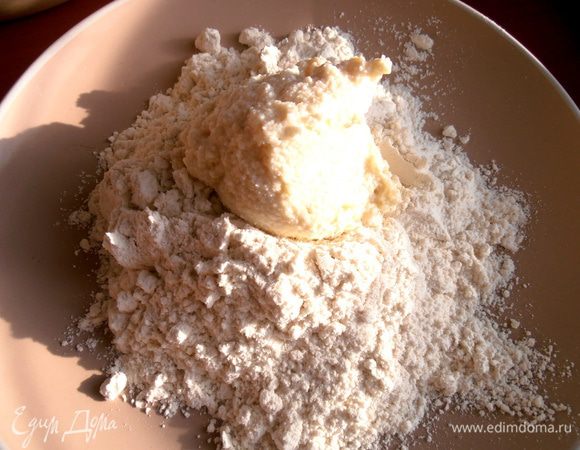 В тарелку или миску насыпаем дополнительную муку и выкладываем в неё столовую ложку теста.