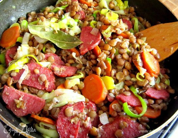 Добавить чечевицу с морковью, перемешать и при необходимости подсолить. Готовить на маленьком огне 5 мин.