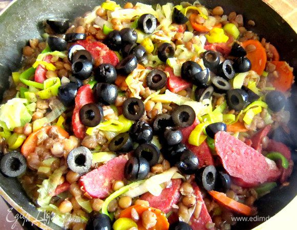 Добавить маслины, приправить свежемолотым чёрным перцем, аккуратно перемешать. 