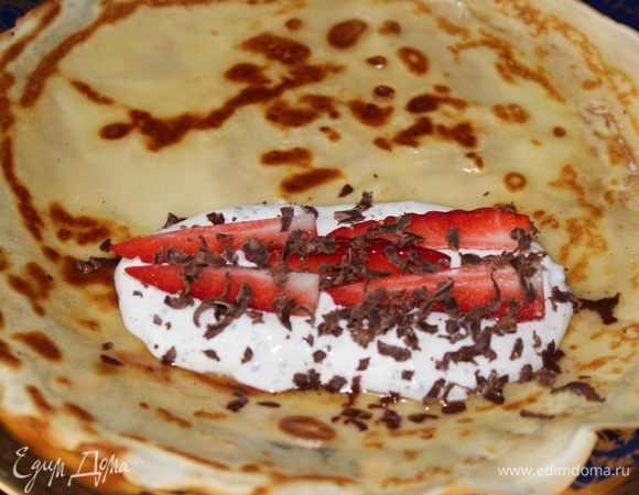 Для другой начинки: выложить на край блина творог, сверху нарезанную клубнику и тертый шоколад. Свернуть трубочкой