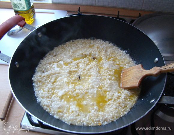 Всыпать рис, прогреть его минуты 2-3, залить вином, добавить немного (1 чашку) горячего бульона/воды, чтобы он слегка покрыл рис