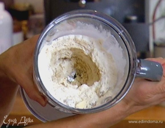 Половину муки с разрыхлителем, 50 г орехов и сливочное масло измельчить в блендере в мелкую крошку.