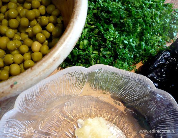 Достаем форму, выкладываем сверху чернослив, горошек, распределяем натертый на мелкой терке чеснок, рубленую зелень и выливаем сметану. Снова закрываем фольгой и ставим в  выключенную духовку еще минут на 10. 