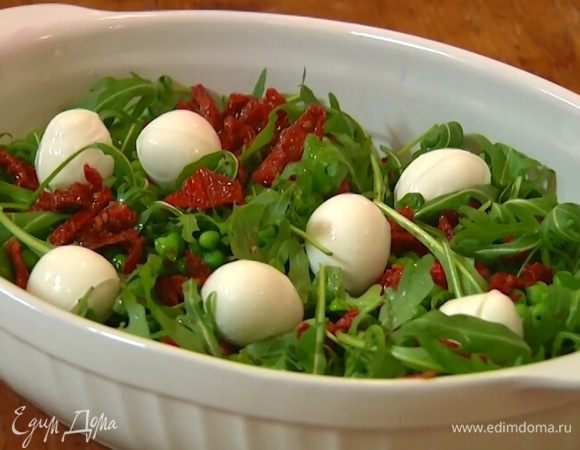 Руколу разложить на блюде, посыпать гранатовыми зернами и горошком, сверху поместить моцареллу.