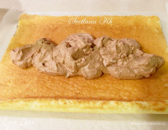 Перевернуть плат теста рисунком вниз и нанести крем. Разровнять и свернуть рулетом. 