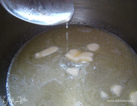 Убрать кастрюлю с огня, добавить масло, размешать до полного растворения
