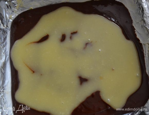 Выложить в форму половину шоколадной смеси. Сверху - половину карамели. 