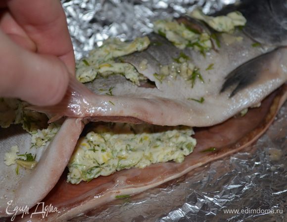 Рыбу выложить на смазанную растительным маслом фольгу. внутрь рыбы кладем застывшее масло и с верху на ней тоже раскладываем кусочки масла. 