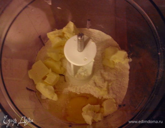 Я замешивала тесто в комбайне. Выложить смесь в чашу, добавить яйцо и нарезанное на кусочки масло. Смешать слегка, только до бразования колобка.