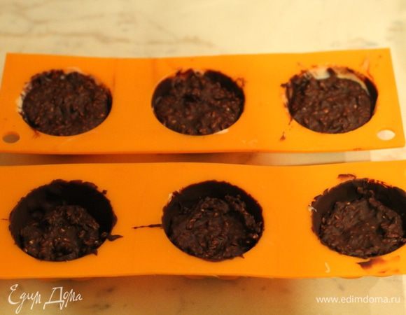 Начинка. Кунжут обжарить на сухой сковороде до золотистого цвета, смешать с частью темного шоколада и слегка охладить. Наполнить конфеты начинкой. Охладить в морозильной камере 10 минут.