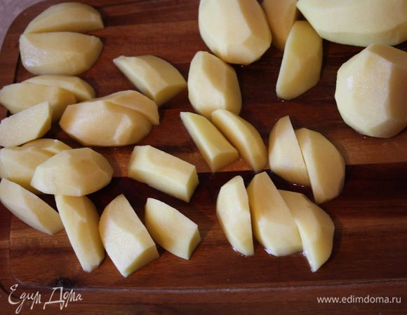 Помыть и почистить картофель.Нарезать примерно одинаковыми дольками. Духовку включить на 200 градусов.В духовку ставим сухой противень. Нужно,чтобы он раскалился.