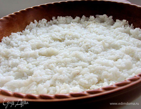 Форму для запекания смажьте сливочным маслом. Выложите отварной рис ровным слоем.