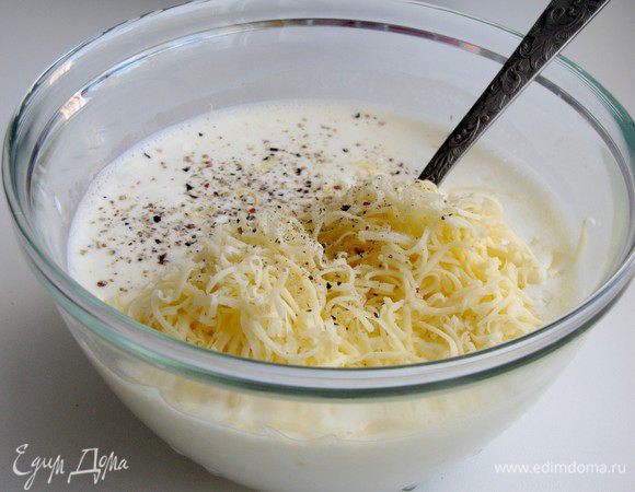 Приготовьте заливку. Слегка взбейте яйцо, добавьте сливки, сметану и тертый сыр. Немного посолите и поперчите. Хорошо перемешайте.