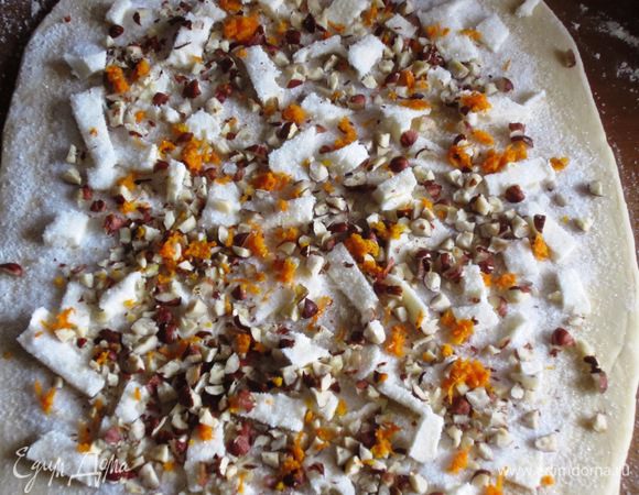 Равномерно распределить кусочки масла,посыпать сахаром,фундуком и апельсиновой цедрой.