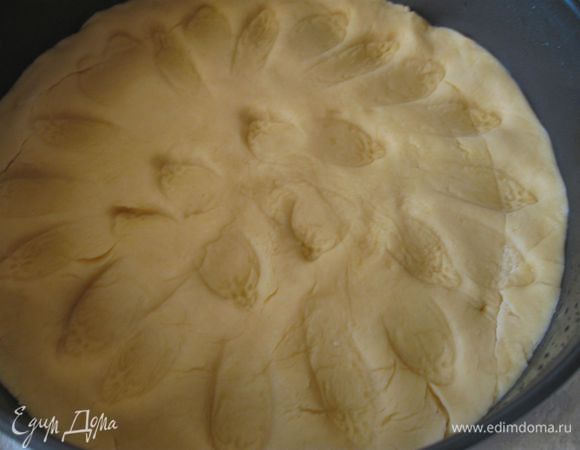 Достать  тесто из холодильника, раскатать  на поверхности, присыпанной мукой. Смазать форму маслом  и выложить  на нее тесто.  Ложкой сделать  на тесте небольшие углубления. 