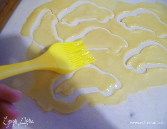 Вырезать и украсить пирог фигурками, смазать их маслом, перенести на пирог.