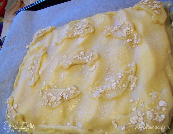 Посыпать фигурки овсяными хлопьями, а весь пирог сахаром. 
Поставить пирог в духовку, разогретую до 190 градусов, выпекать 35-40 минут, до золотистого цвета.