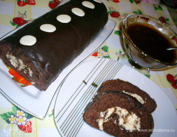 Остывший рулет смазываем глазурью. Для глазури растопим на водяной бане шоколад с маслом и дадим немного остыть. Я выложила рулет на пергамент, на котором он выпекался и медленно поливала его глазурью из чайной ложечки. Потеков на стол и потерь глазури при этом у меня не было. Украсила рулет дисками из белого шоколада. Даем глазури застыть, выкладываем рулет на блюдо, нарезаем на порции и наслаждаемся волшебным шоколадным вкусом. Приятного вам аппетита!