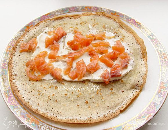 На готовые блинчики выложить нужное количество начинки - рыбу и сыр, свернуть рулетиком. Варьируйте количество начинки по своему вкусу.