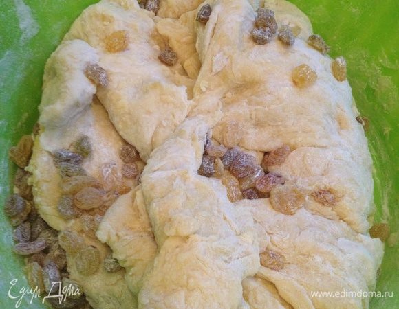 Изюм засыпать в тесто и продолжать месить, пока оно не перестанет липнуть к рукам и станет однородным и гладким.