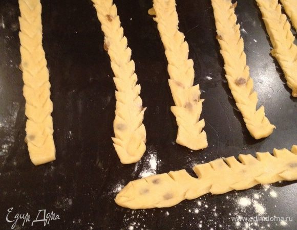 Тесто, которое мы отложили для полосок, также раскатываем в пласт, вырезаем несколько полосок, шириной около 3 см и длиной = длине пирога, делаем надрезы ножницами по всей длине полосок в виде елочки и украшаем пирог! Здесь много места для фантазии!