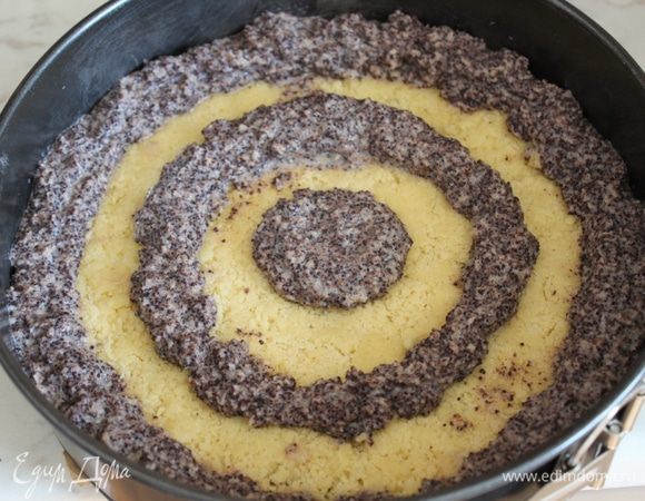 Выложить маковую начинку в кондитерский мешок с насадкой, имеющей круглое отверстие. Выложить на корж в  середину и еще 2 кольца на расстоянии 2-3 см 