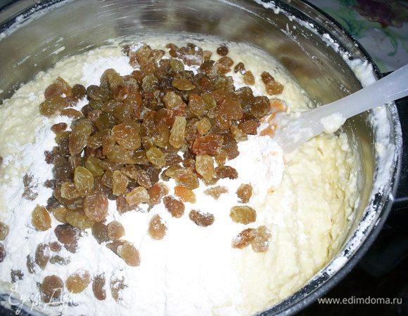Затем на полученную массу просеиваем муку с разрыхлителем. А сверху высыпаем промытый изюм.