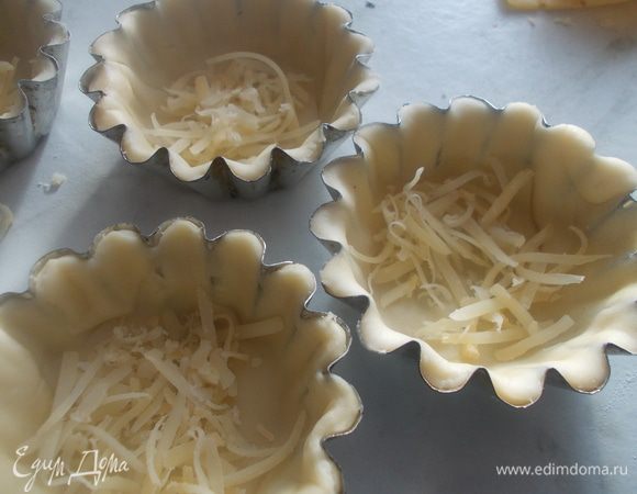 на дно каждой формочки посыпать немного сыра.