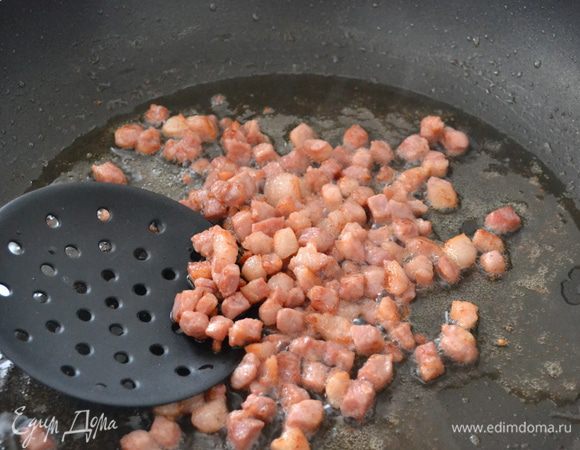 Как только бекон поджарился, шумовкой достаем его из сковороды и откладываем в сторону.