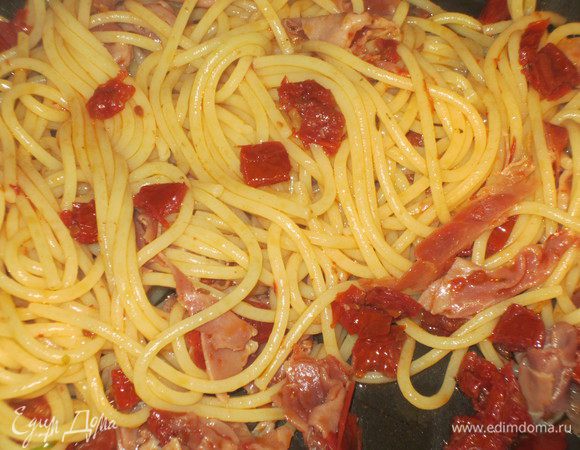 Отварить спагетти согласно инструкции на упаковке,откинуть на дуршлаг, добавить к помидорам, перемешать и прогреть на сильном огне 2 минуты.