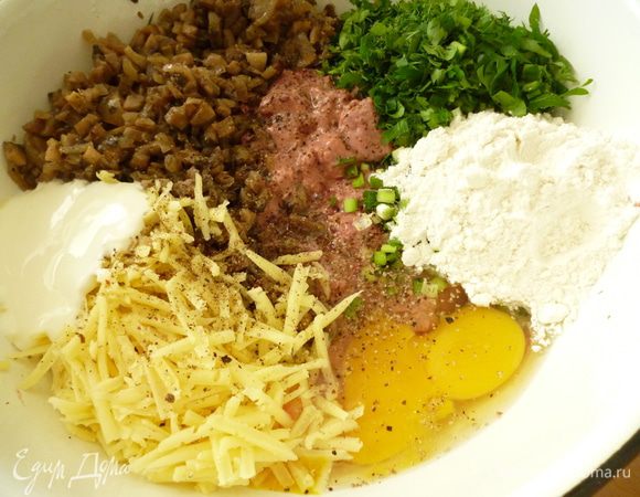 Остывшую печень нарезать кусочкам примерно 1,5-2 см. Добавить мелко нарезанную зелень, яйца, муку, сметану, грибы, натертый на крупной терке сыр, соль и молотый перец.