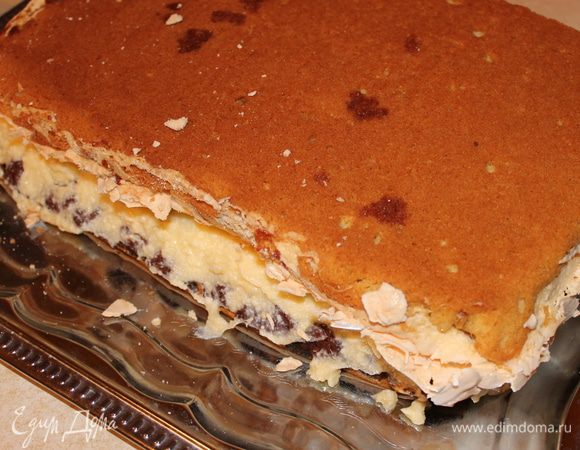 теперь нам надо одну часть пирога, где мак, смазать половиной крема, а другую часть мы переворачиваем и кладем серединой внутрь. Пирог очень хрупкий, поэтому, чтобы не поломать, мы под вторую часть подкладываем доску разделочную и вместе с ней перевернем.