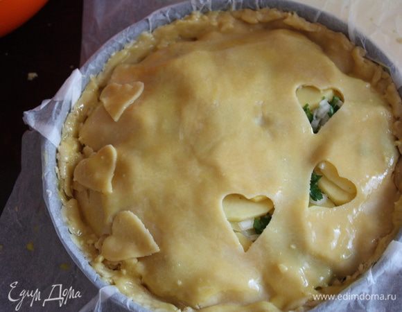 Раскатываем оставшееся тесто (оно тонкое,лучше раскатывать межу двумя листами пергамента,делаем дырочку,я решила вырезать сердечки,можете сделать что-то подобное) и укладываем поверх пирога. Тщательно скрепляем все швы.Смазываем желтком поверхность.